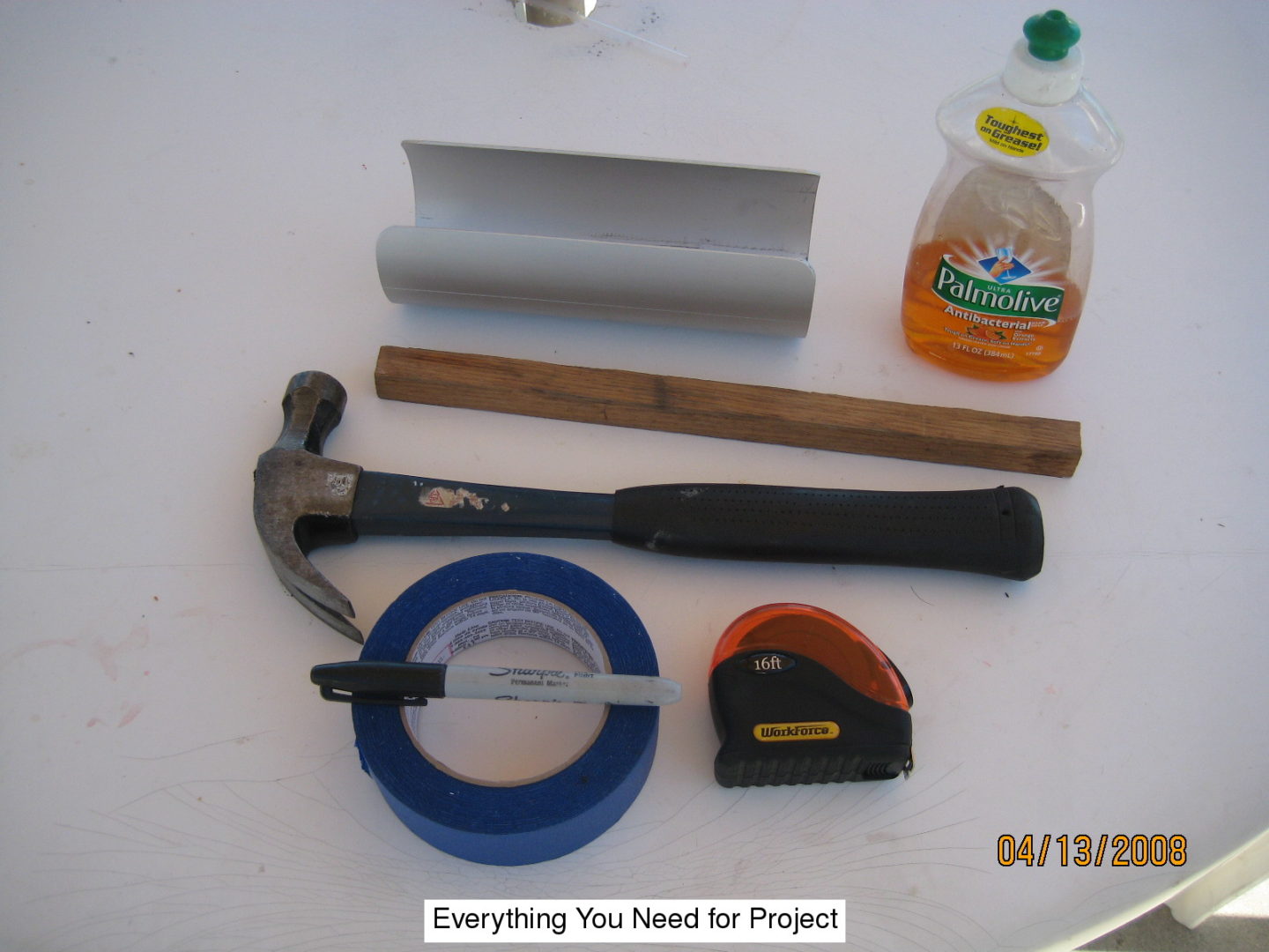 A hammer, tape measure and other tools are laid out on the table.