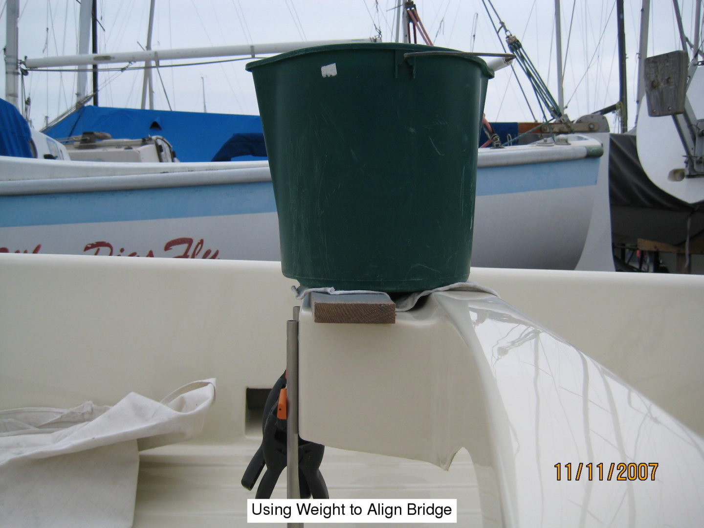 A green bucket is attached to the side of a boat.