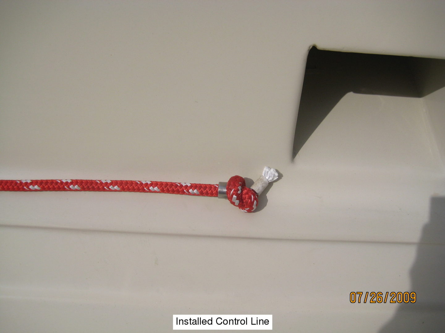 A red rope hanging from the side of a boat.