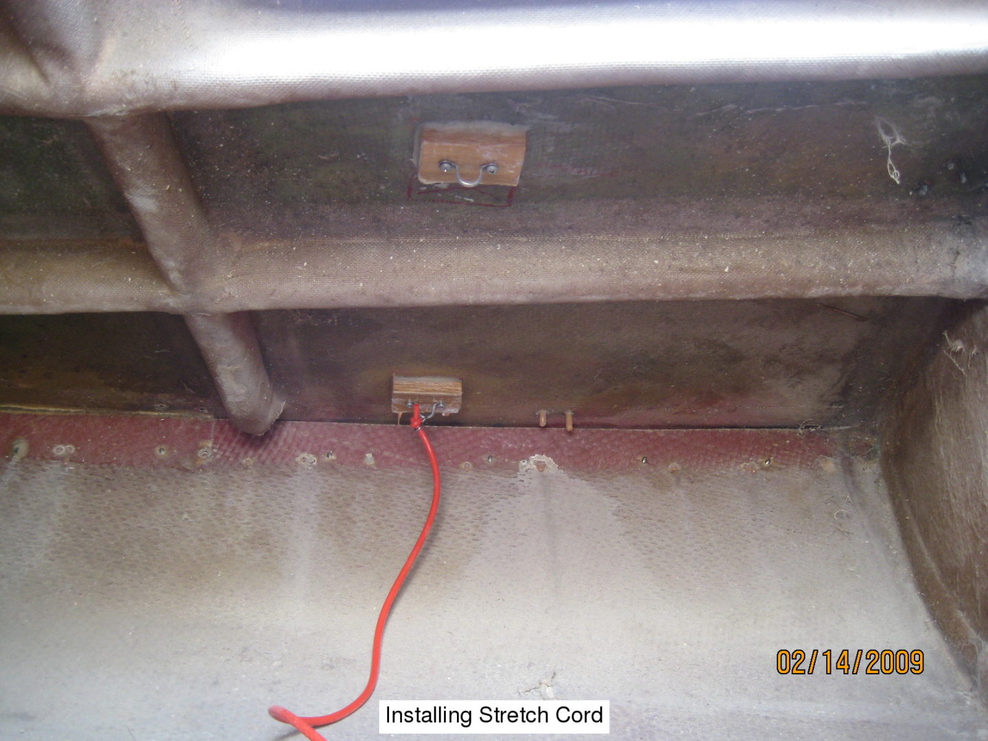 A red wire is connected to the bottom of a metal structure.