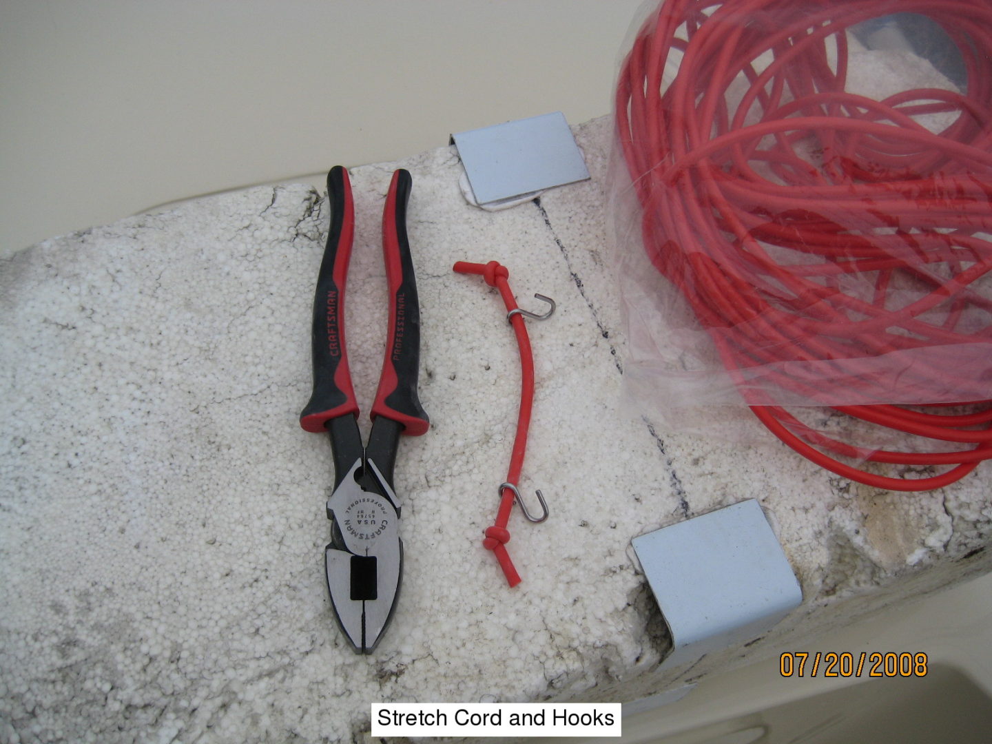 A pair of pliers and some wires on the floor.