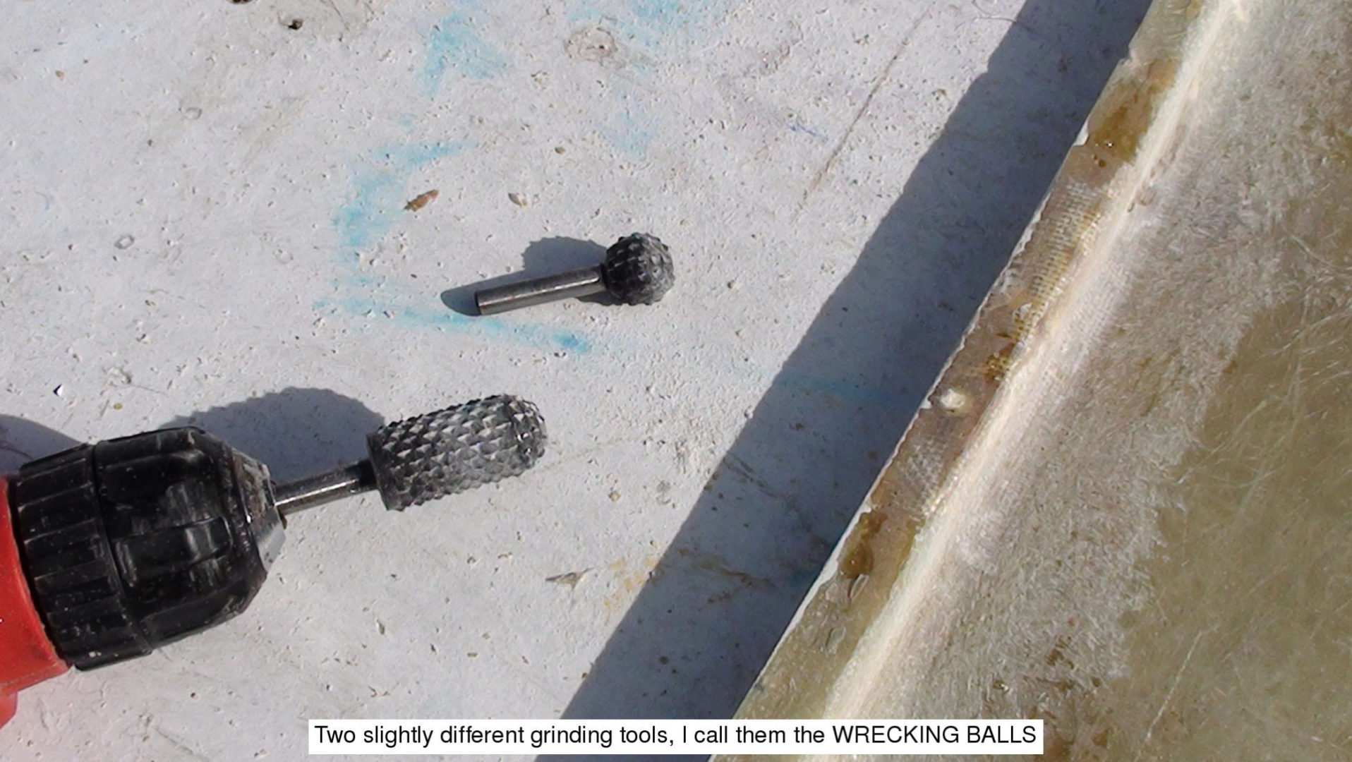 Two different grinding tools are laying on the ground.