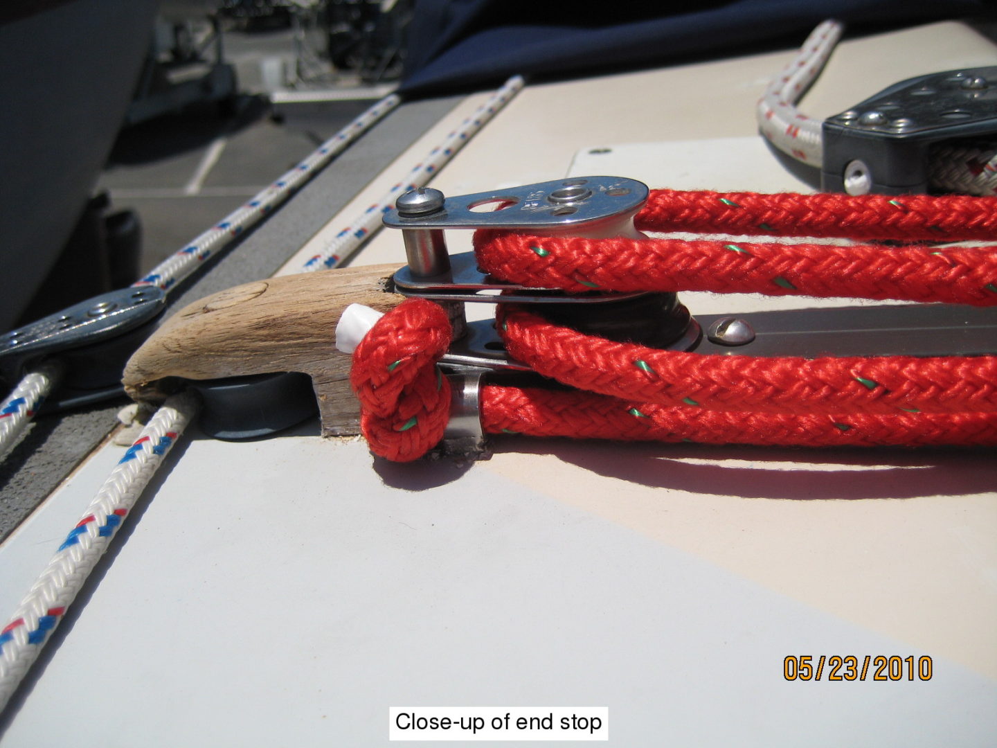 A pair of red rope is attached to a wooden handle.