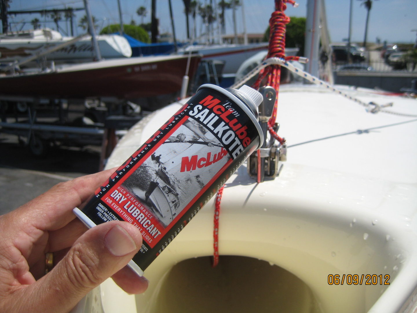 A person holding up a can of sailboat paint.