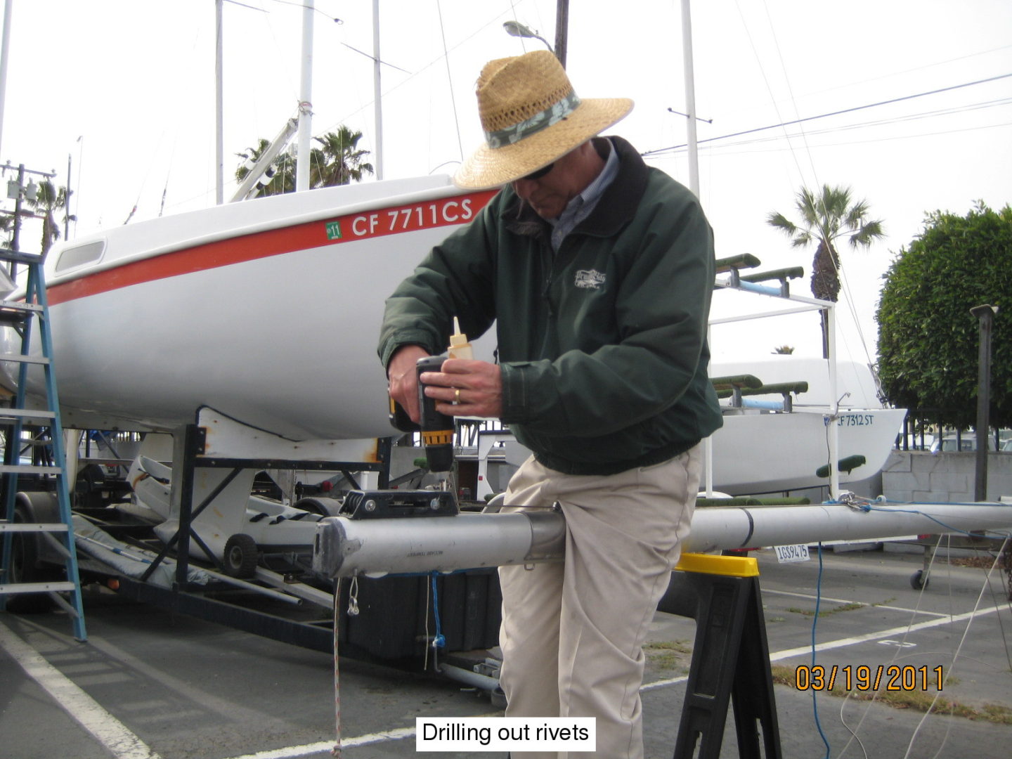 A man in a hat and jacket working on a boat.