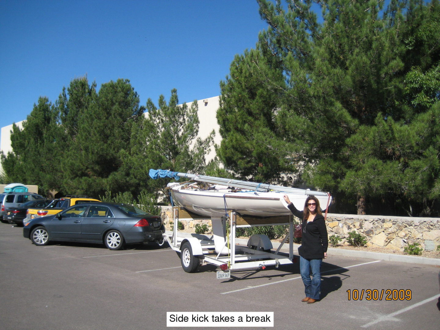 A woman standing next to a boat on the street.