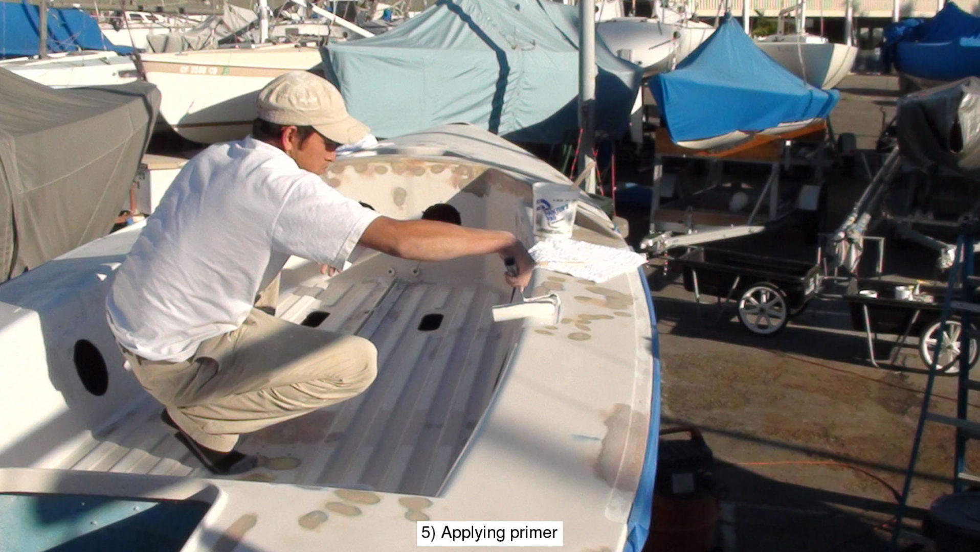 A man is painting the hull of a boat.