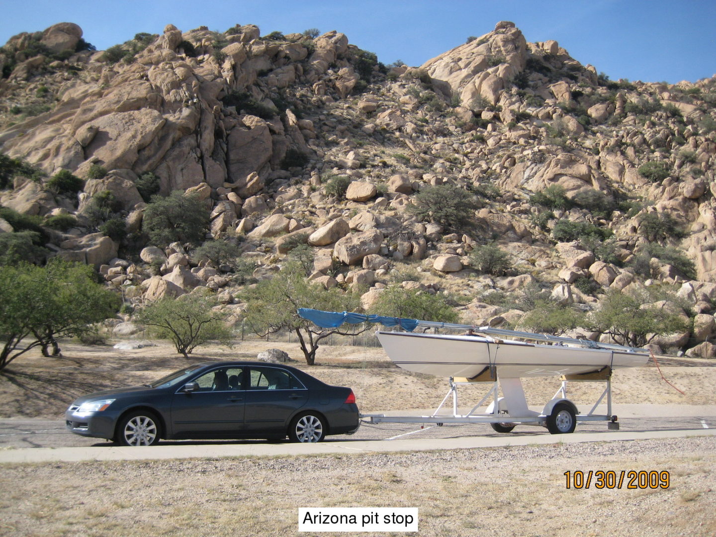 A car parked on the side of a road near some rocks.