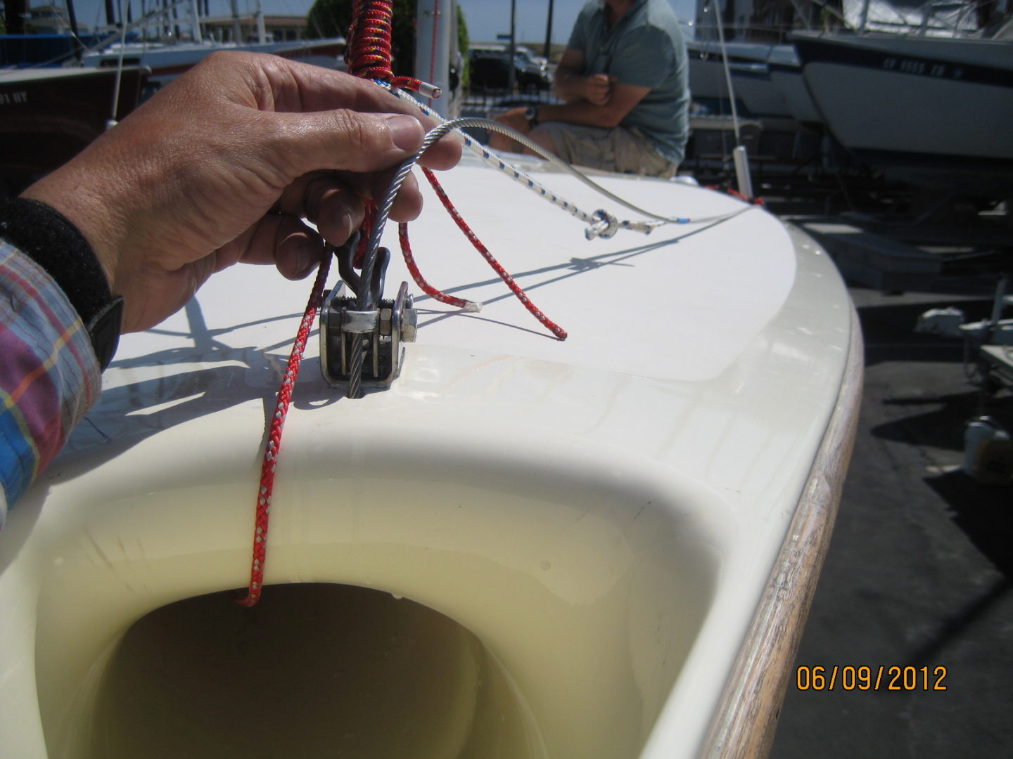 A person is tying the sail on a boat.