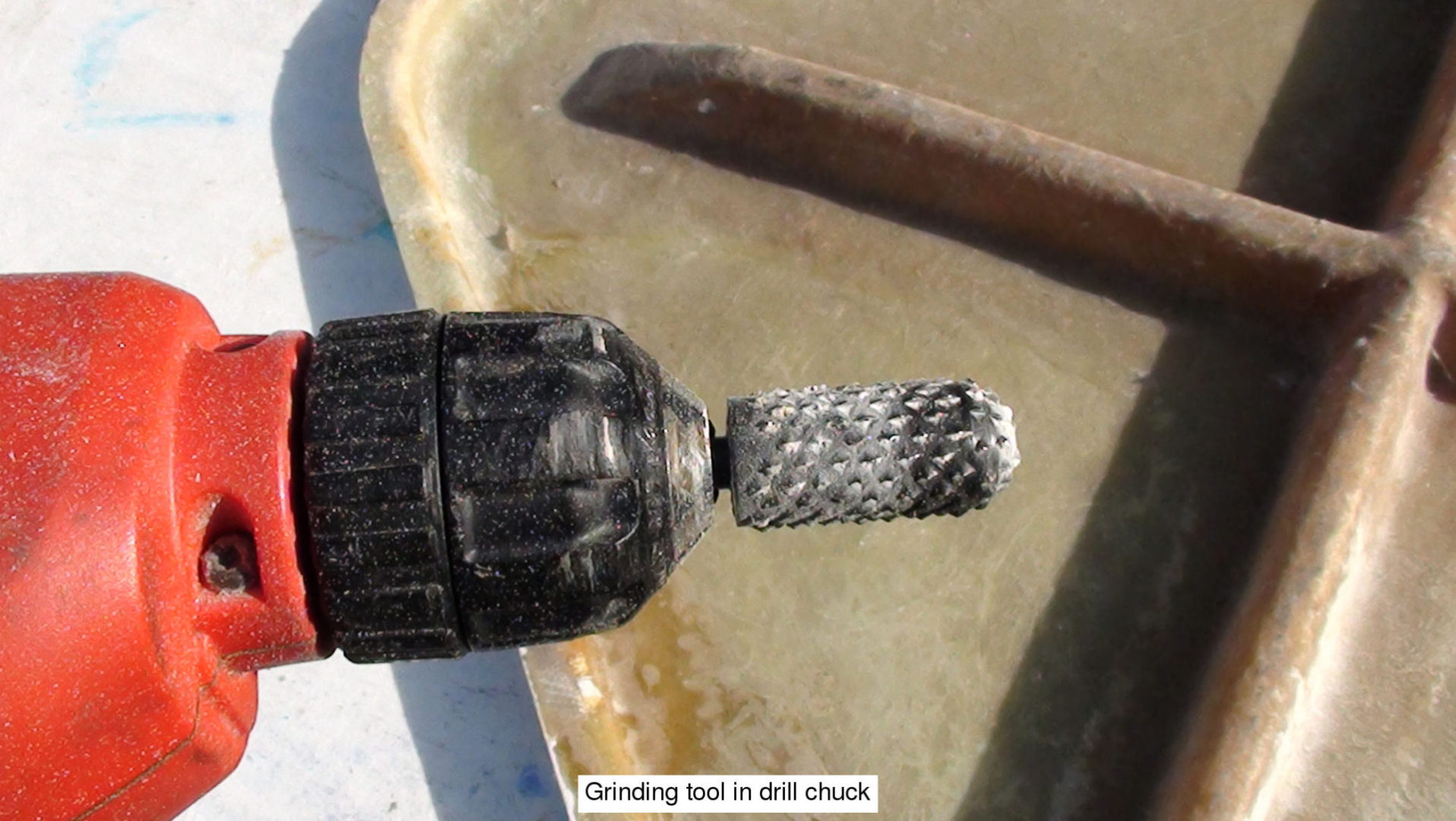 A close up of a drill chuck on the side of a table.