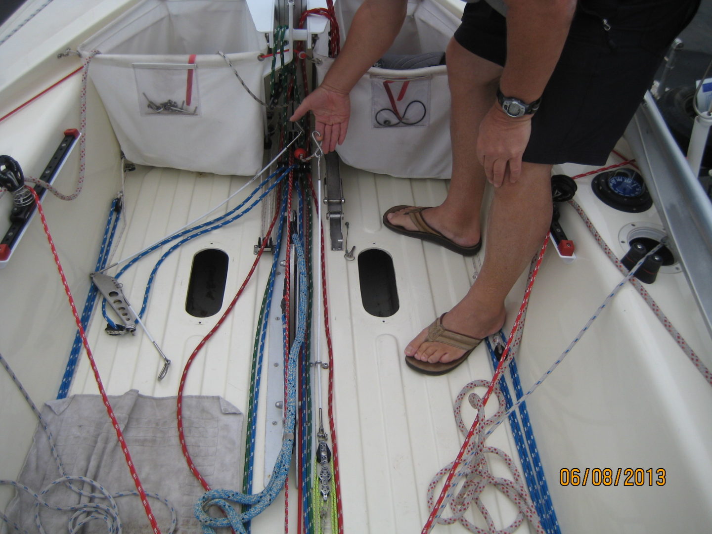 A man is tying ropes on the deck of his boat.