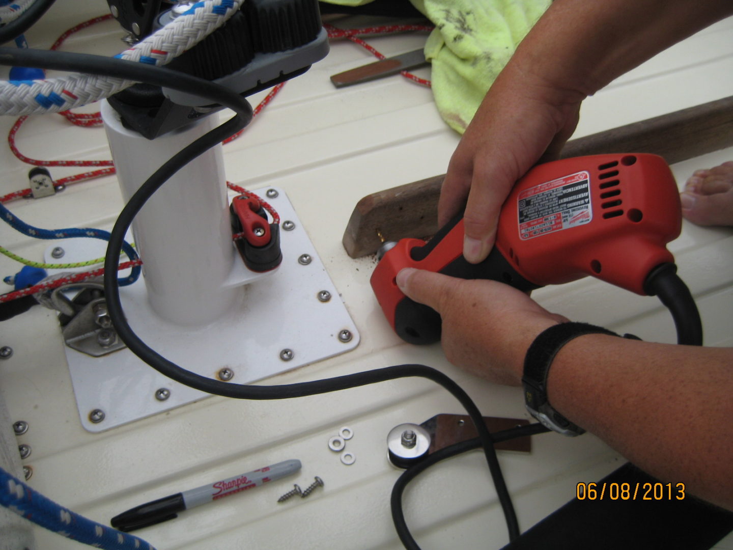 A person using an electric saw to cut the wire.