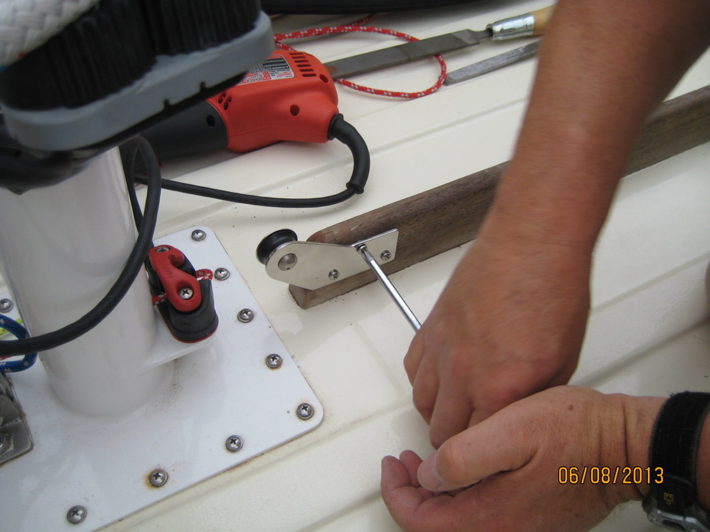 A person using a drill to make holes in the wood.