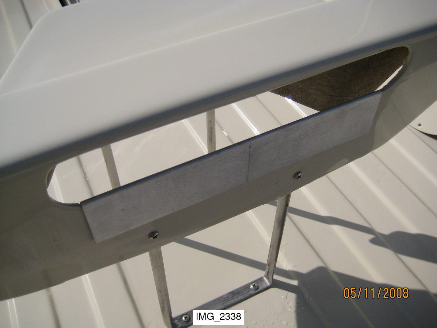 A metal table with two legs and one of the legs is missing.