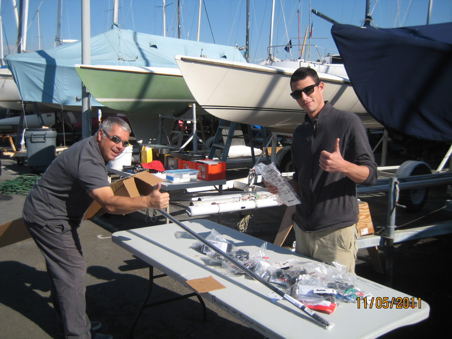 Two men standing at a table with some boats