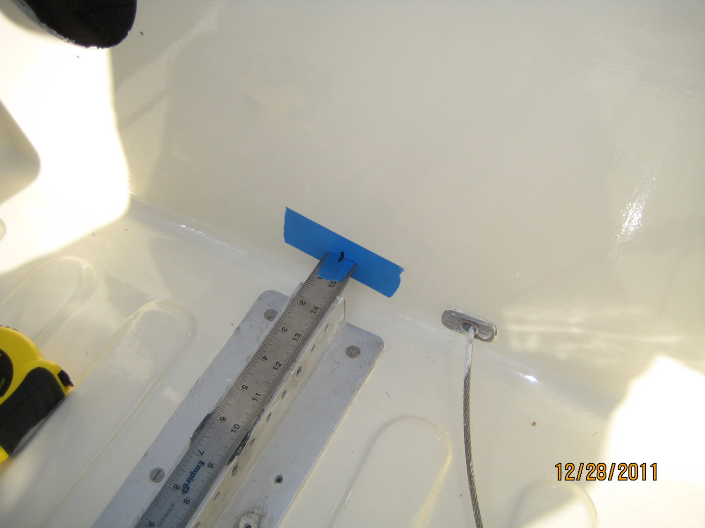 A blue plastic object is attached to the side of a boat.