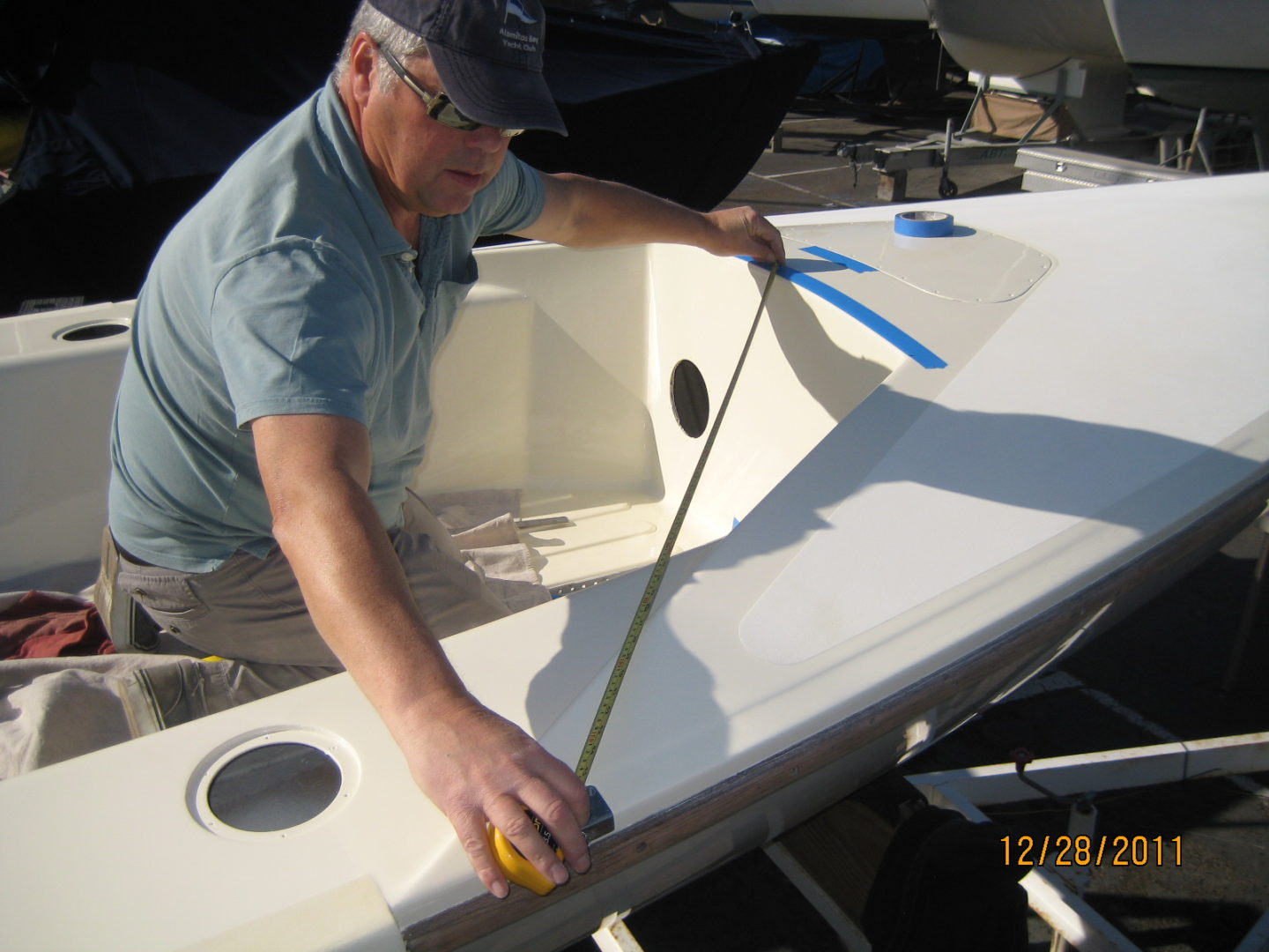 A man measuring the bottom of a boat.