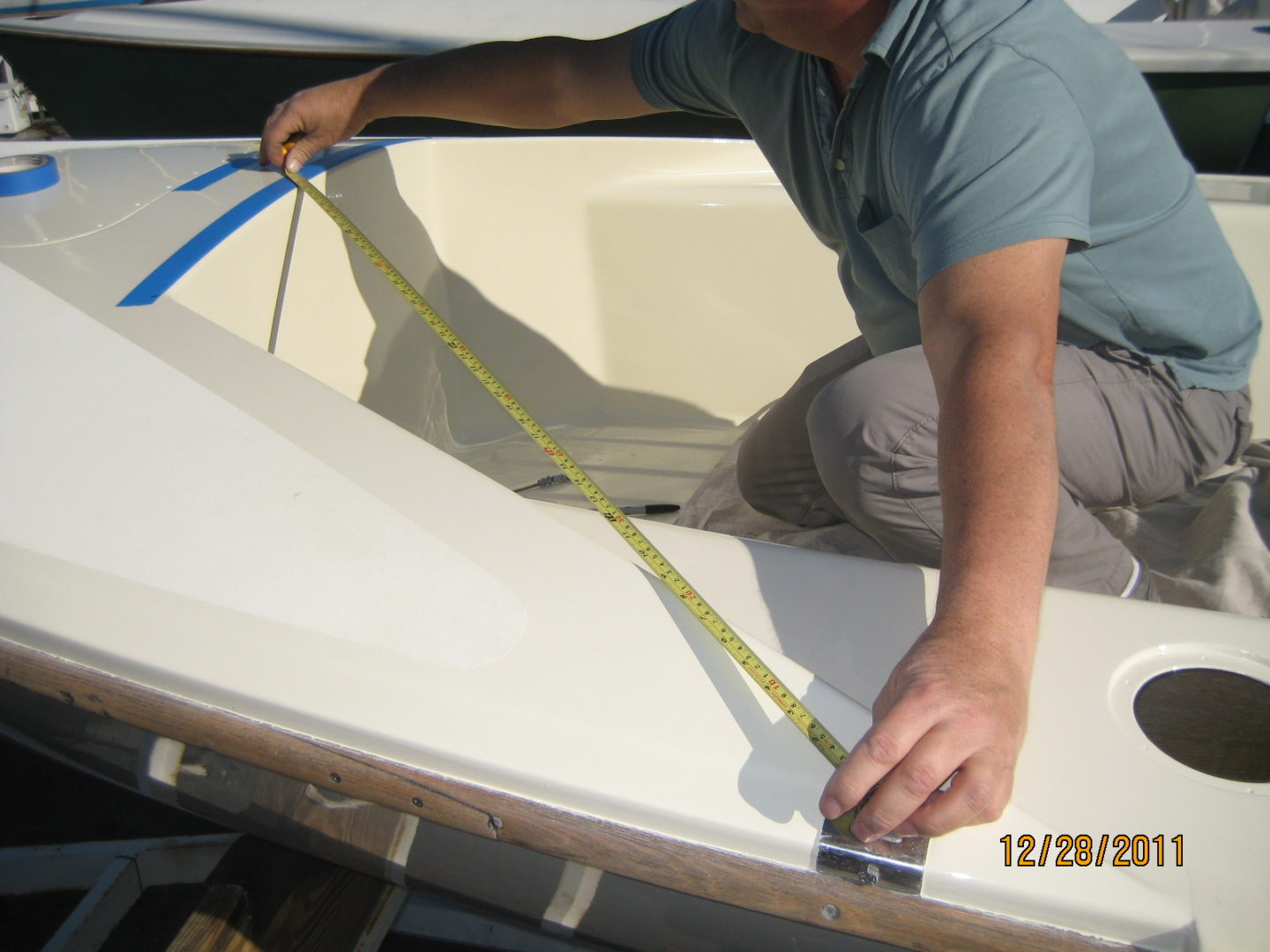 A man measuring the length of a boat.