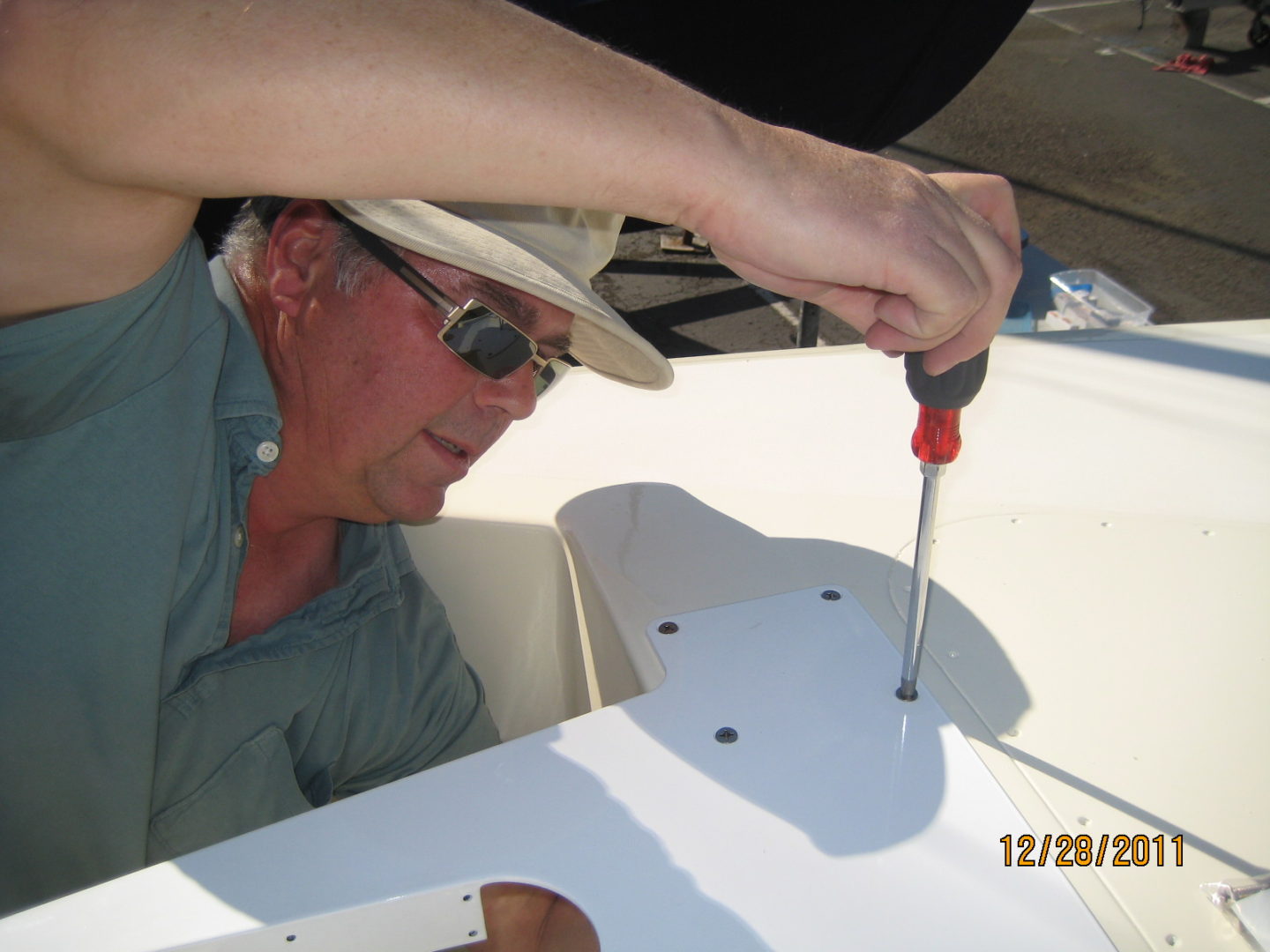 A man is working on something with a screwdriver.