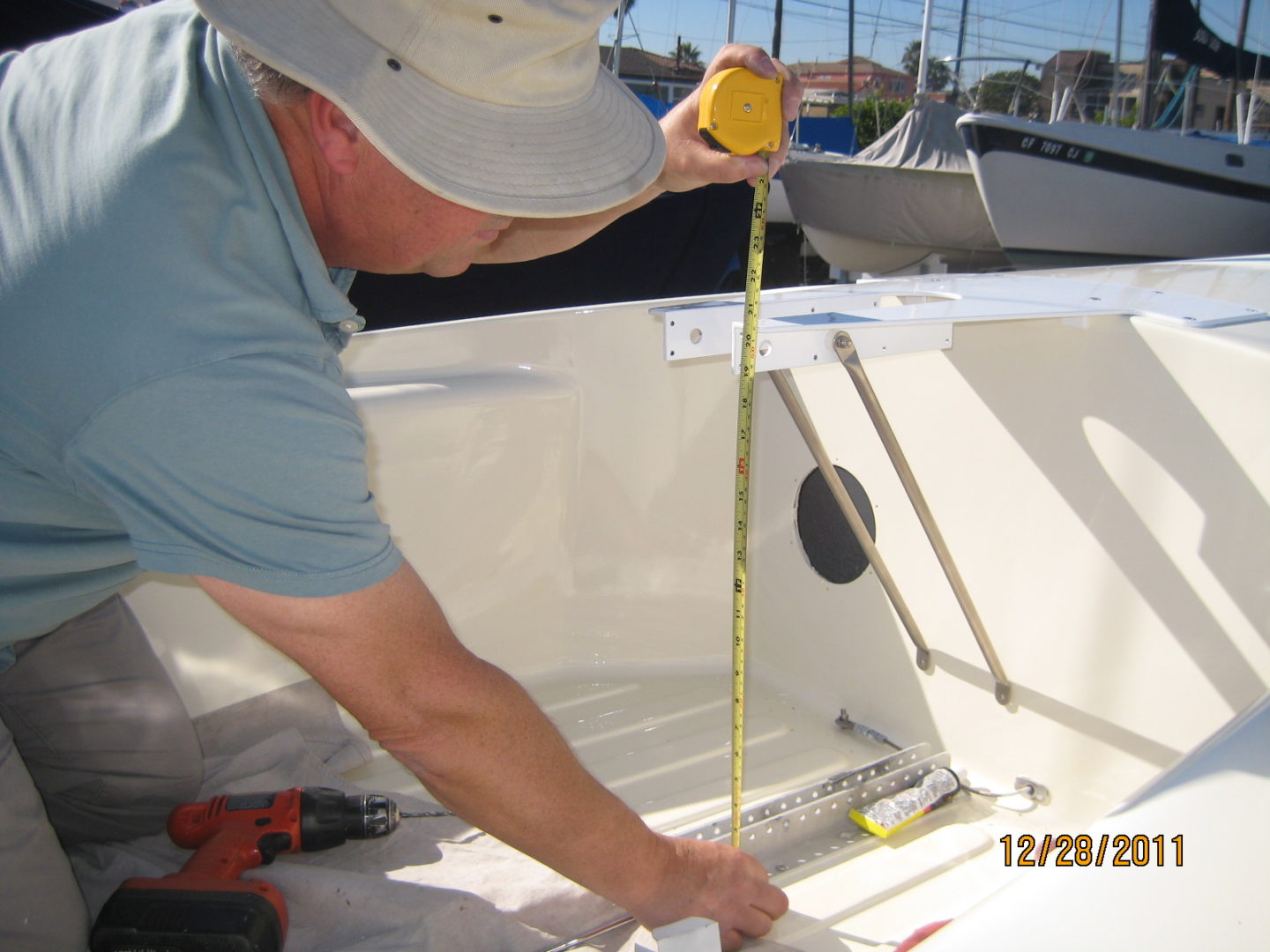 A man measuring the bottom of a boat.