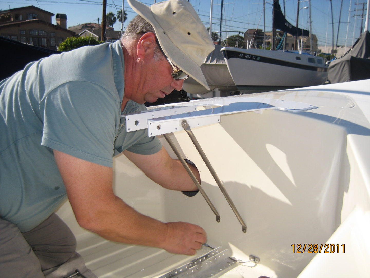 A man in hat and glasses working on a boat.