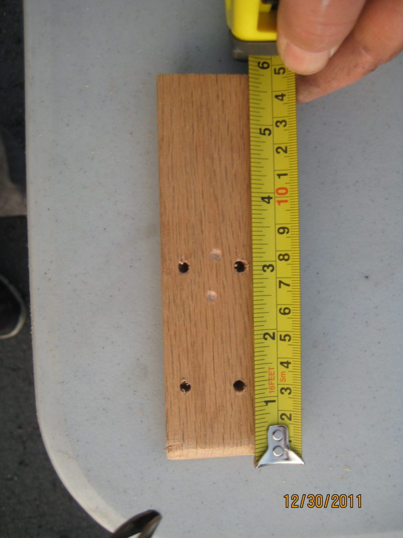 A wooden board with a ruler and some holes