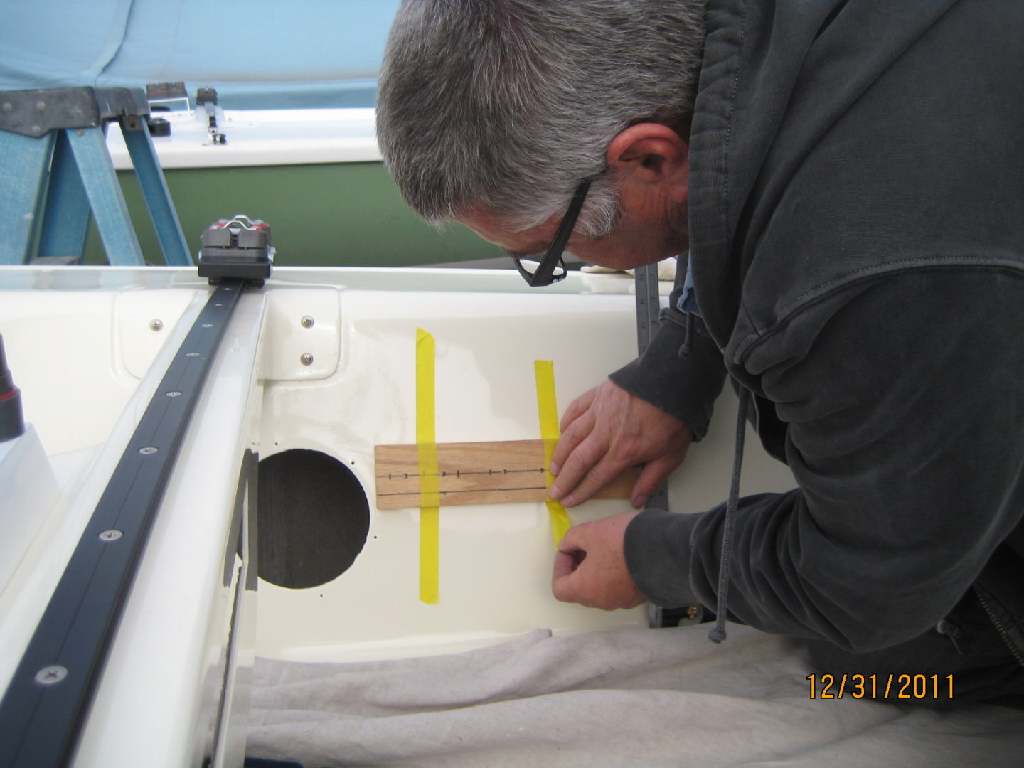 A man measuring the length of a piece of wood.