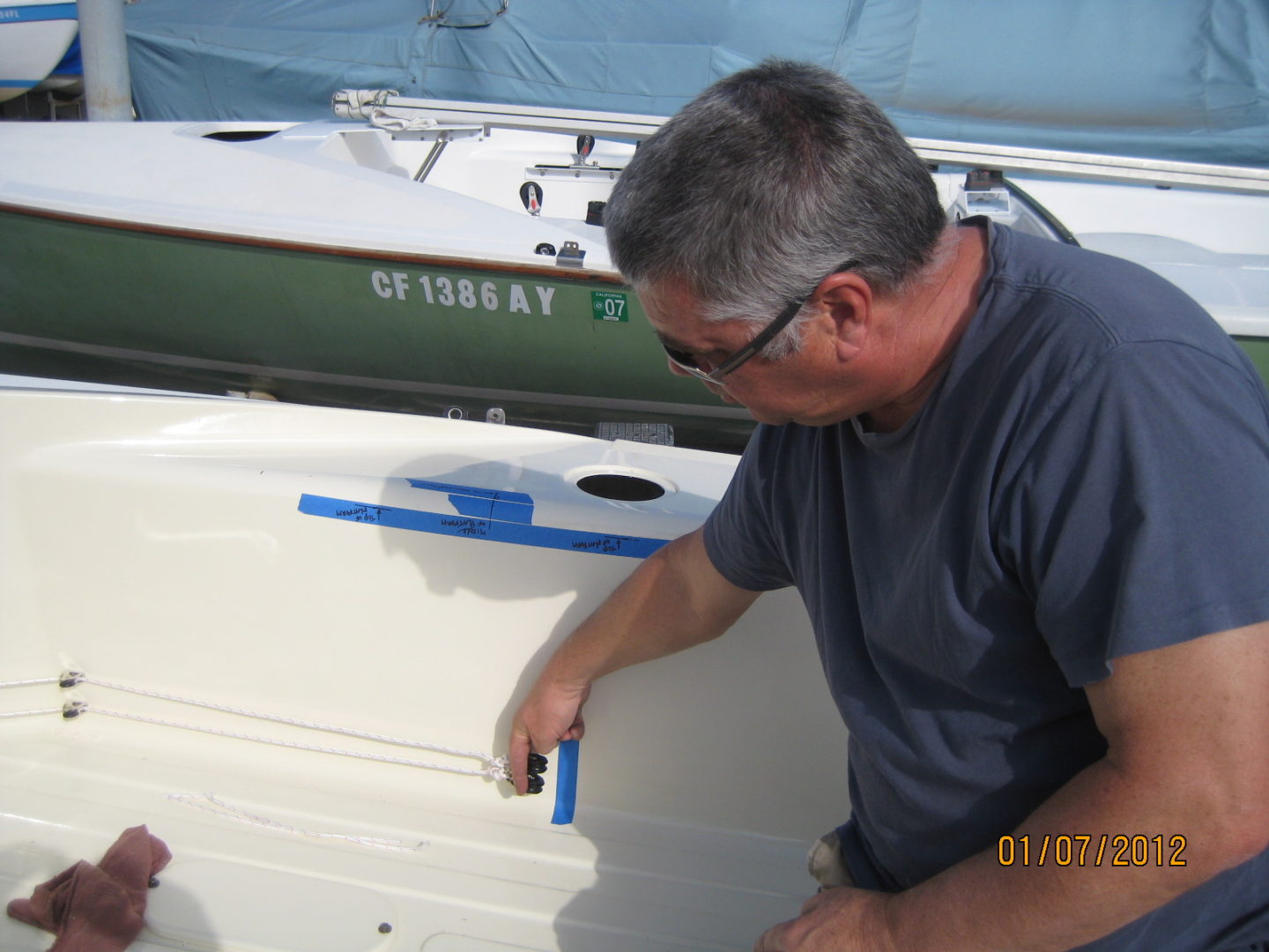 A man painting the side of a boat.