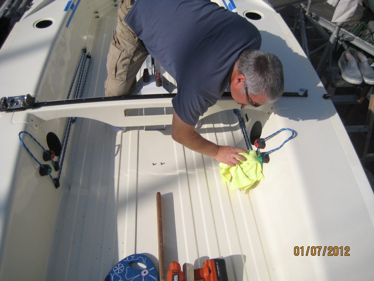 A man is cleaning the deck of his boat.