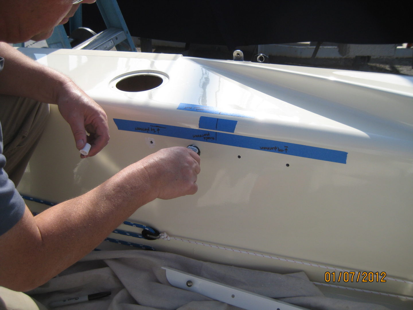 A person painting the side of a boat.