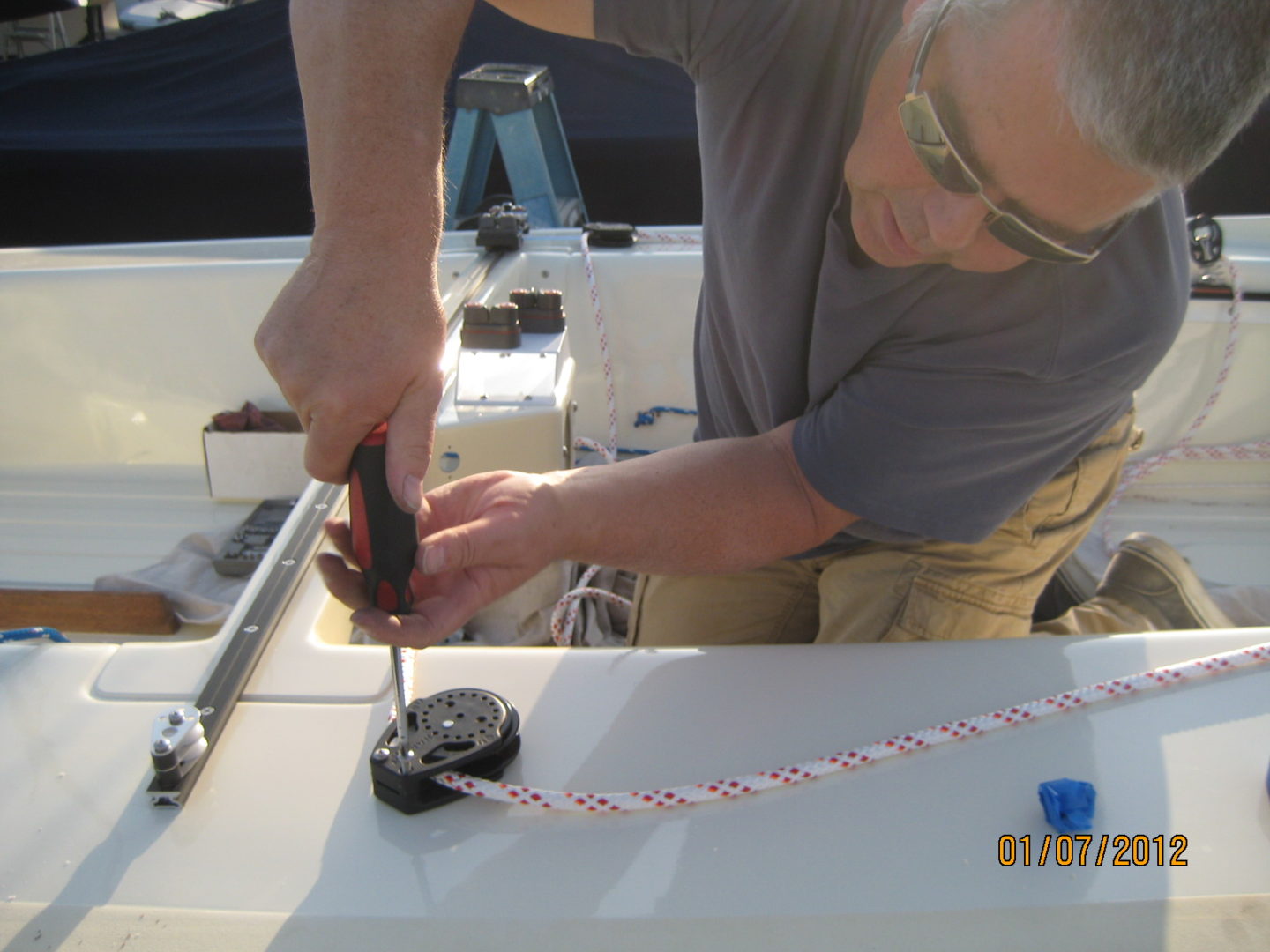 A man working on a boat with a screwdriver.