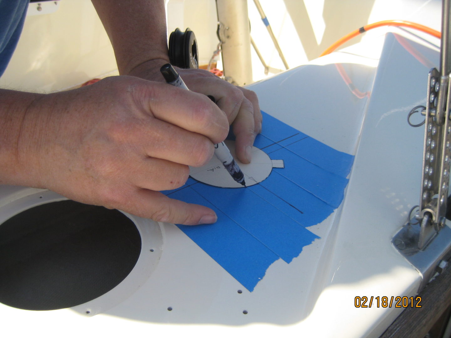 A person is painting on the back of a boat.