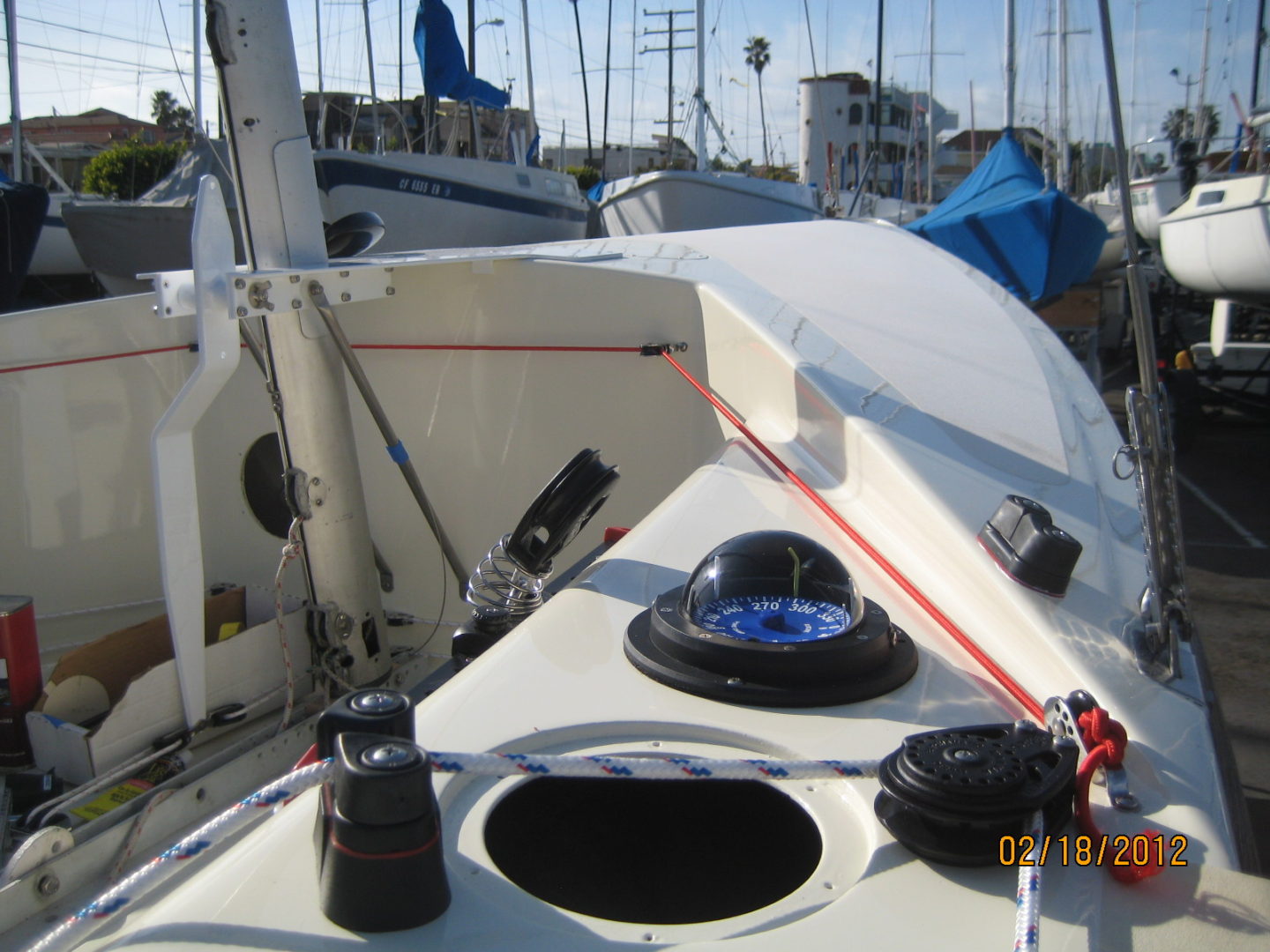 A boat is docked in the water and has a black sail.