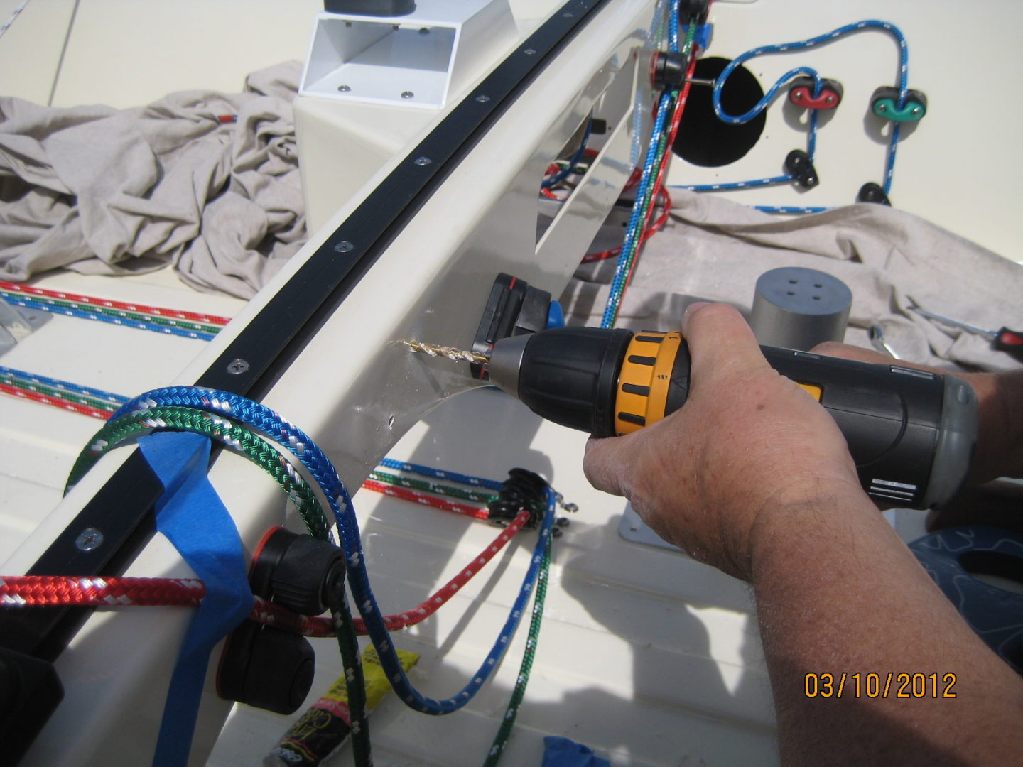 A person using a drill to work on the wiring.