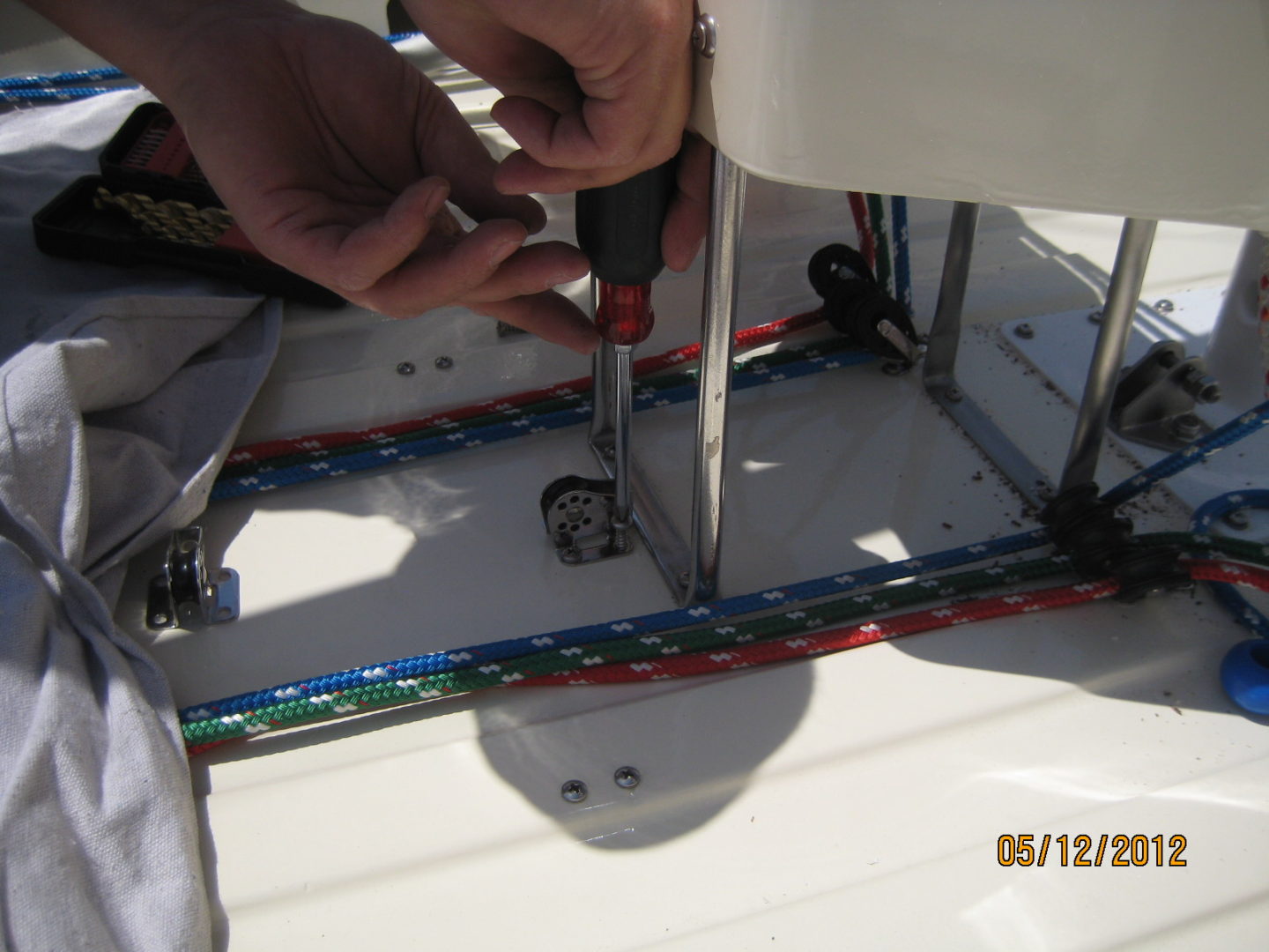 A person using a screwdriver on the bottom of a boat.