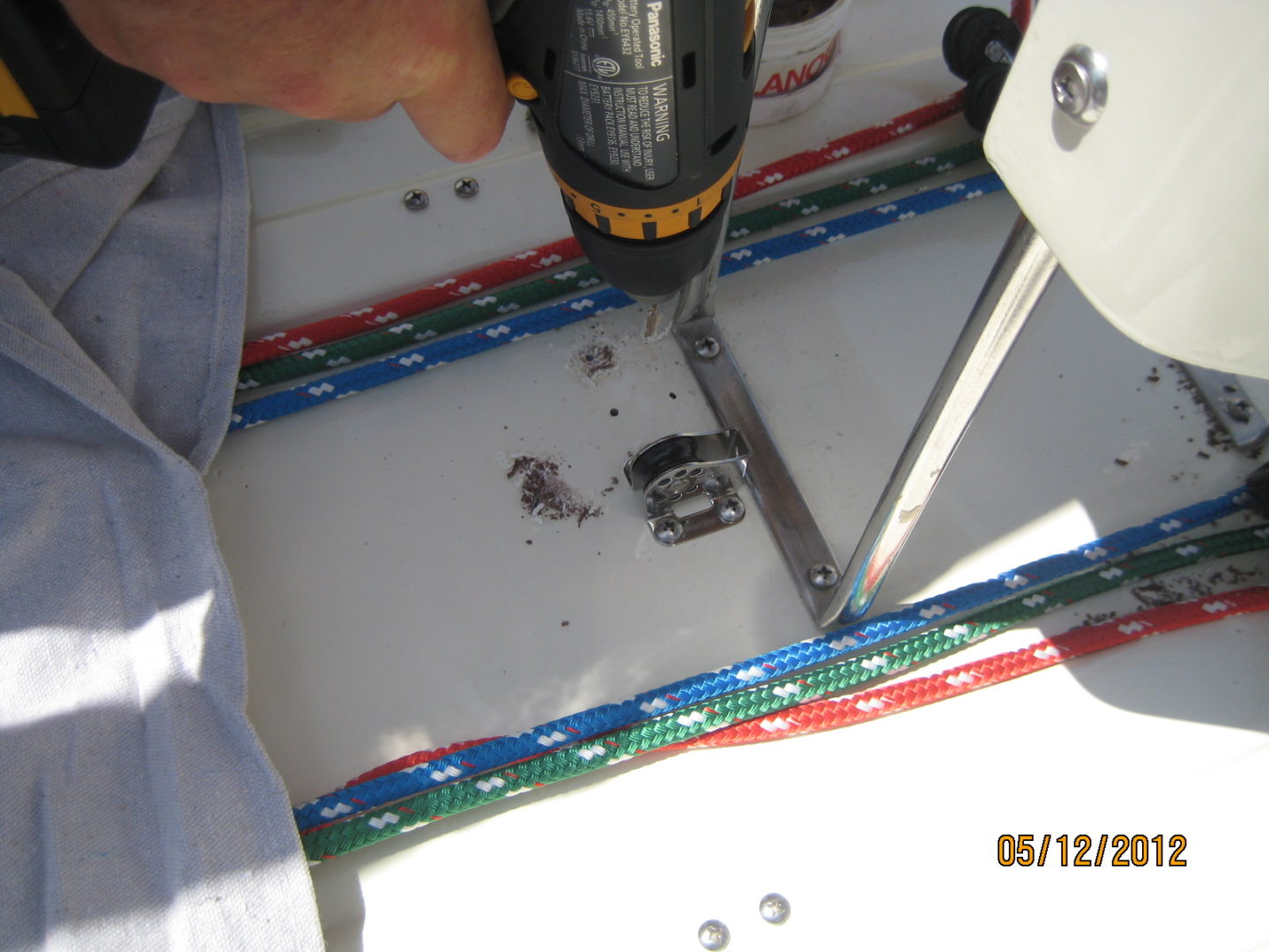 A person using a drill to make holes in the ground.