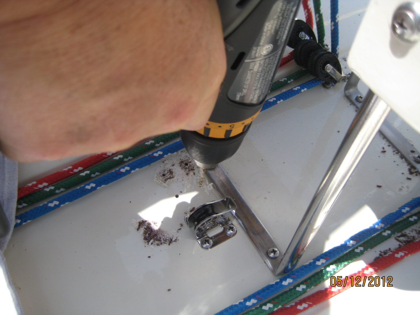 A person using an electric drill to fix the frame of a bicycle.