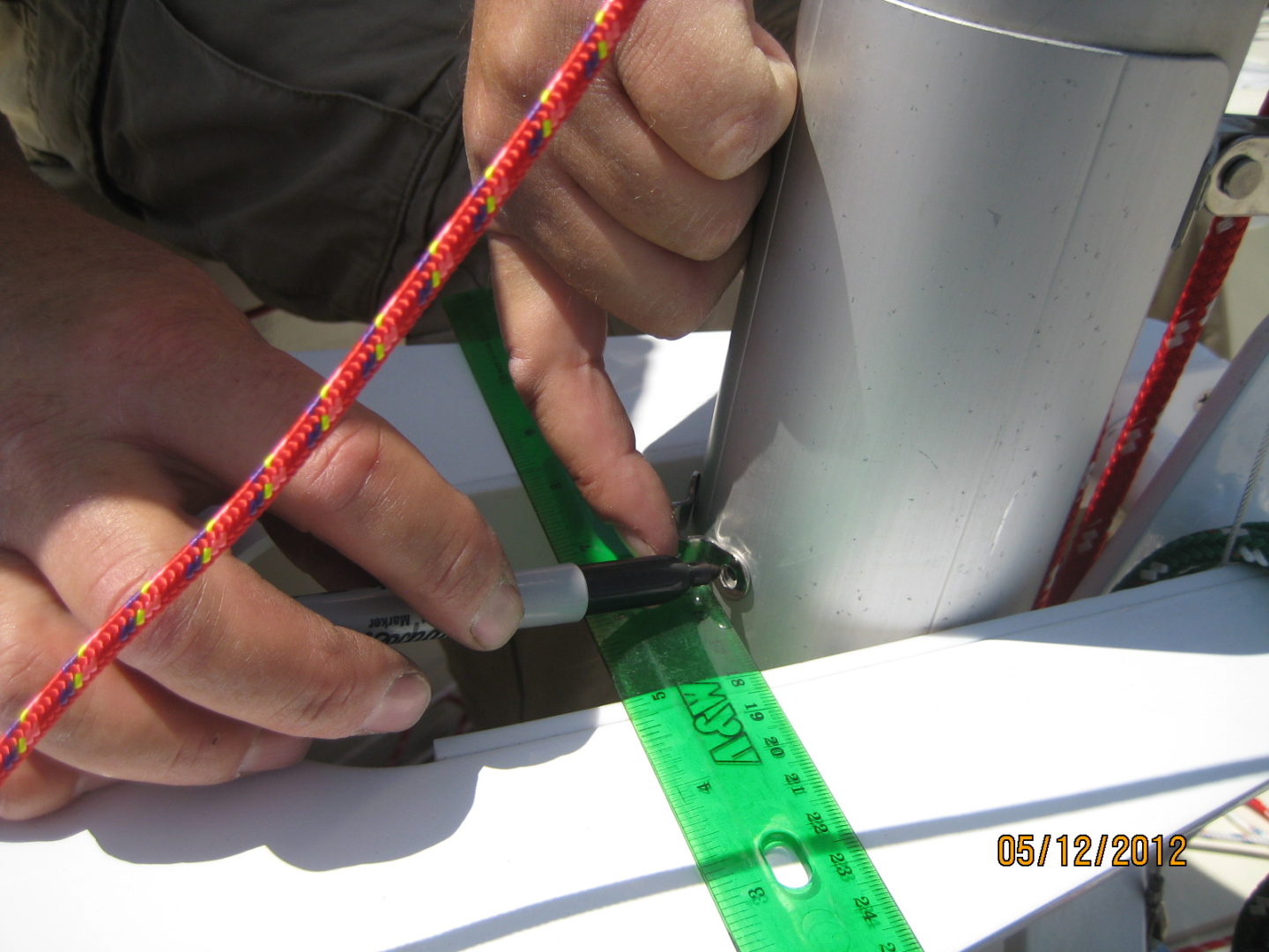 A person cutting tape with scissors and ruler.