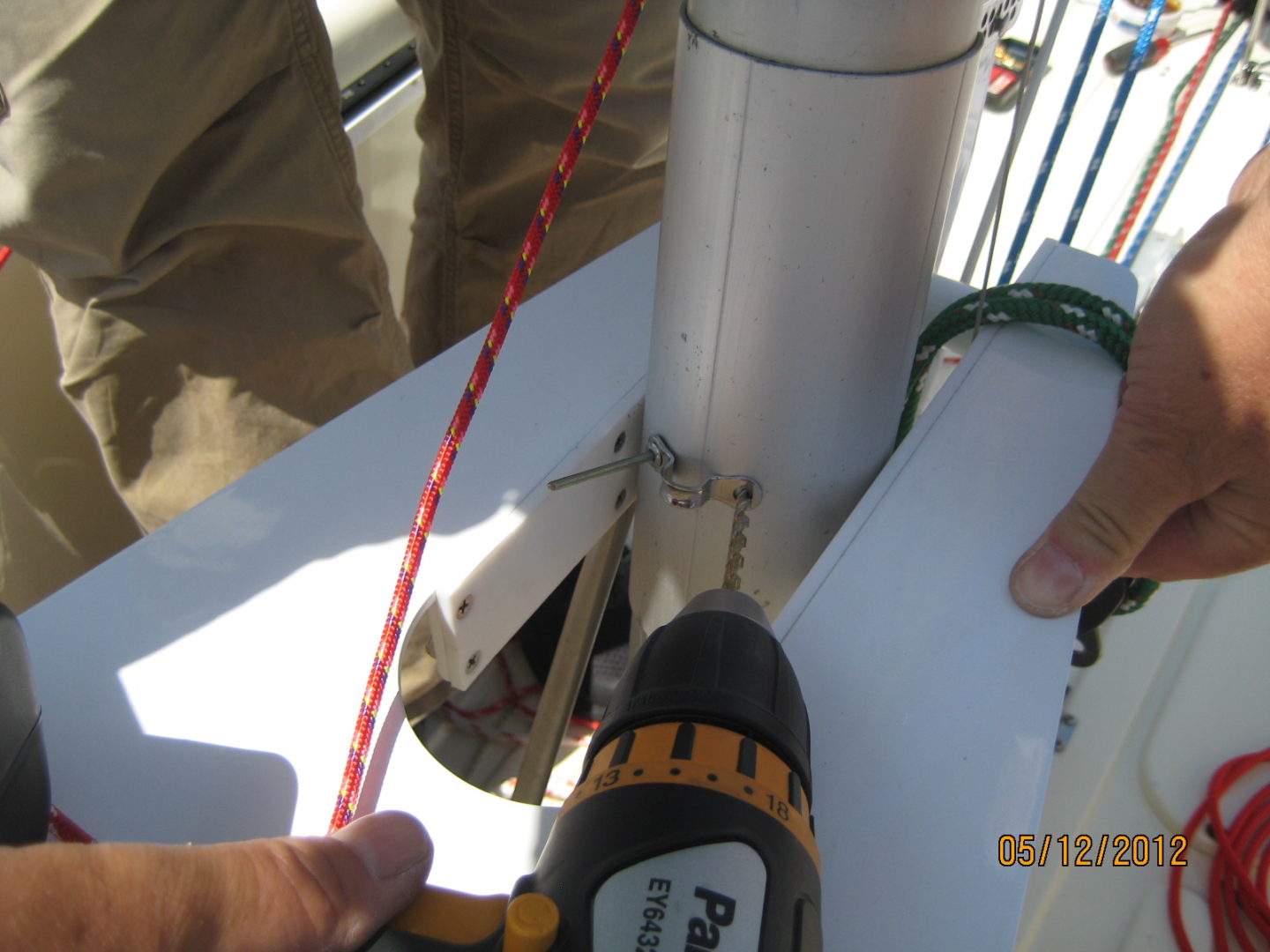 A person using a drill to install the antenna.