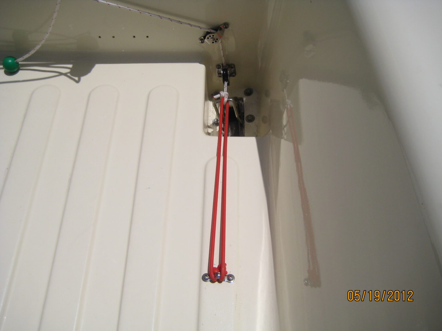 A red hose hanging from the ceiling of an open garage door.