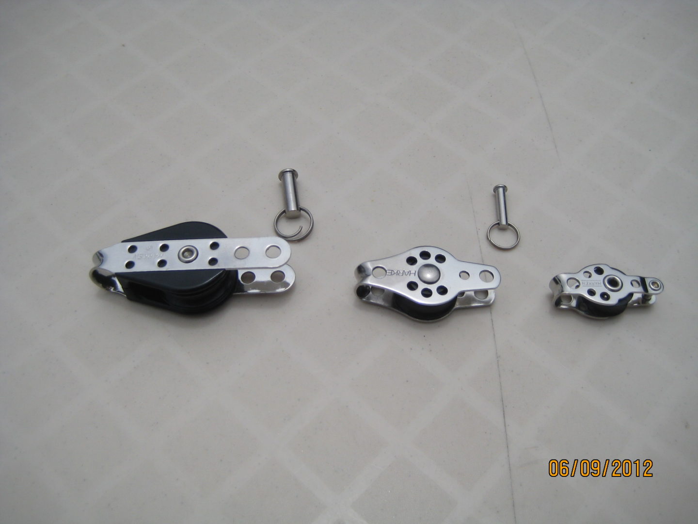 A set of three different sized metal pulleys.