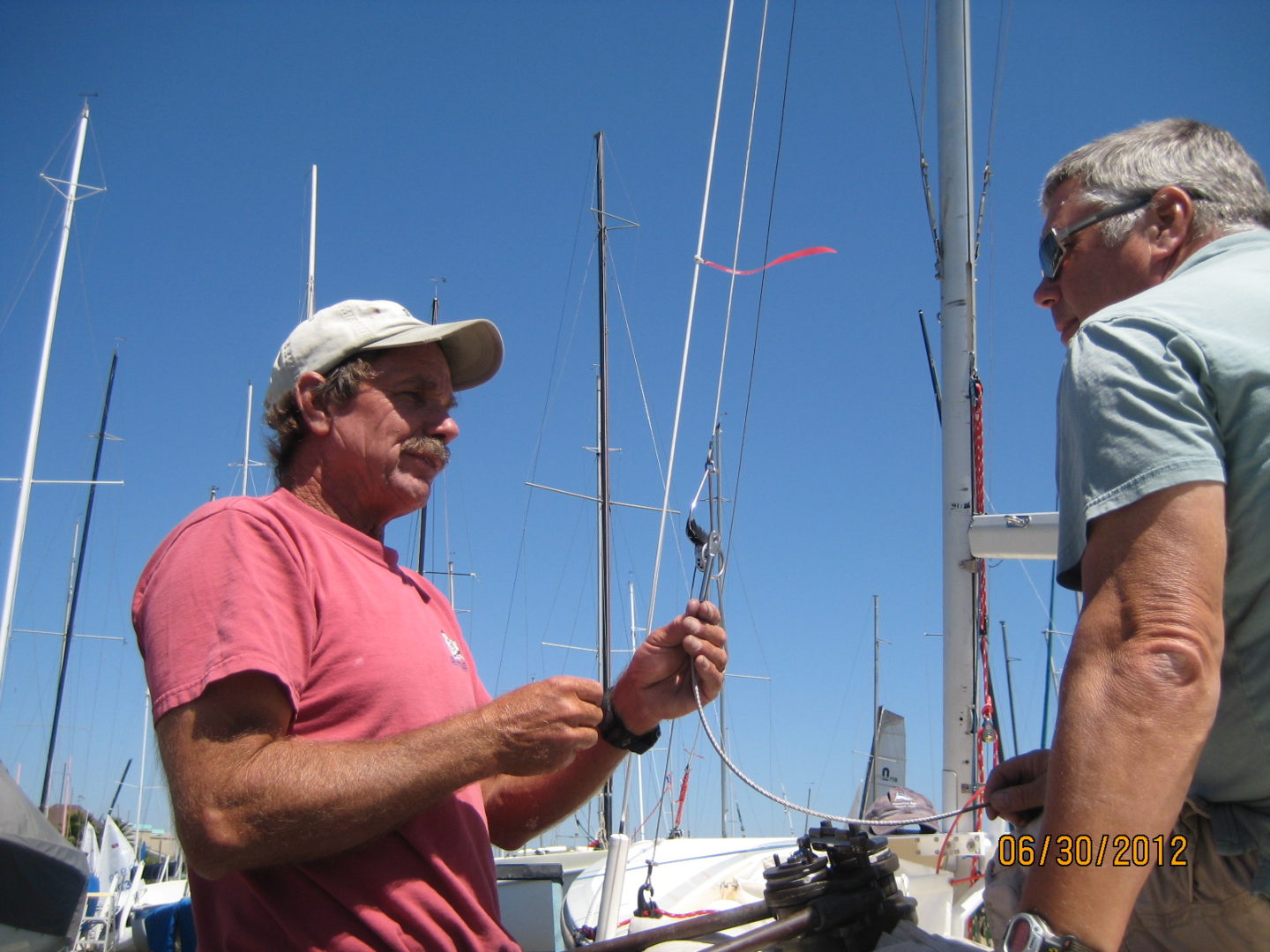 A man holding onto some fishing rods while standing next to another man.