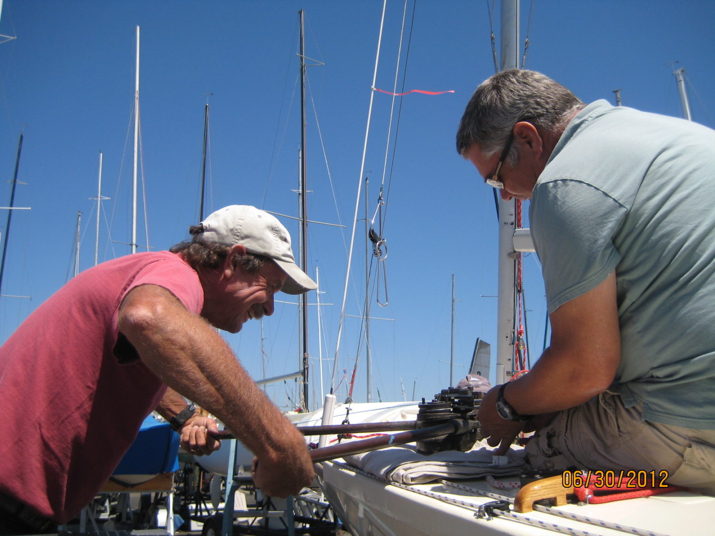 Two men working on a boat in the water.