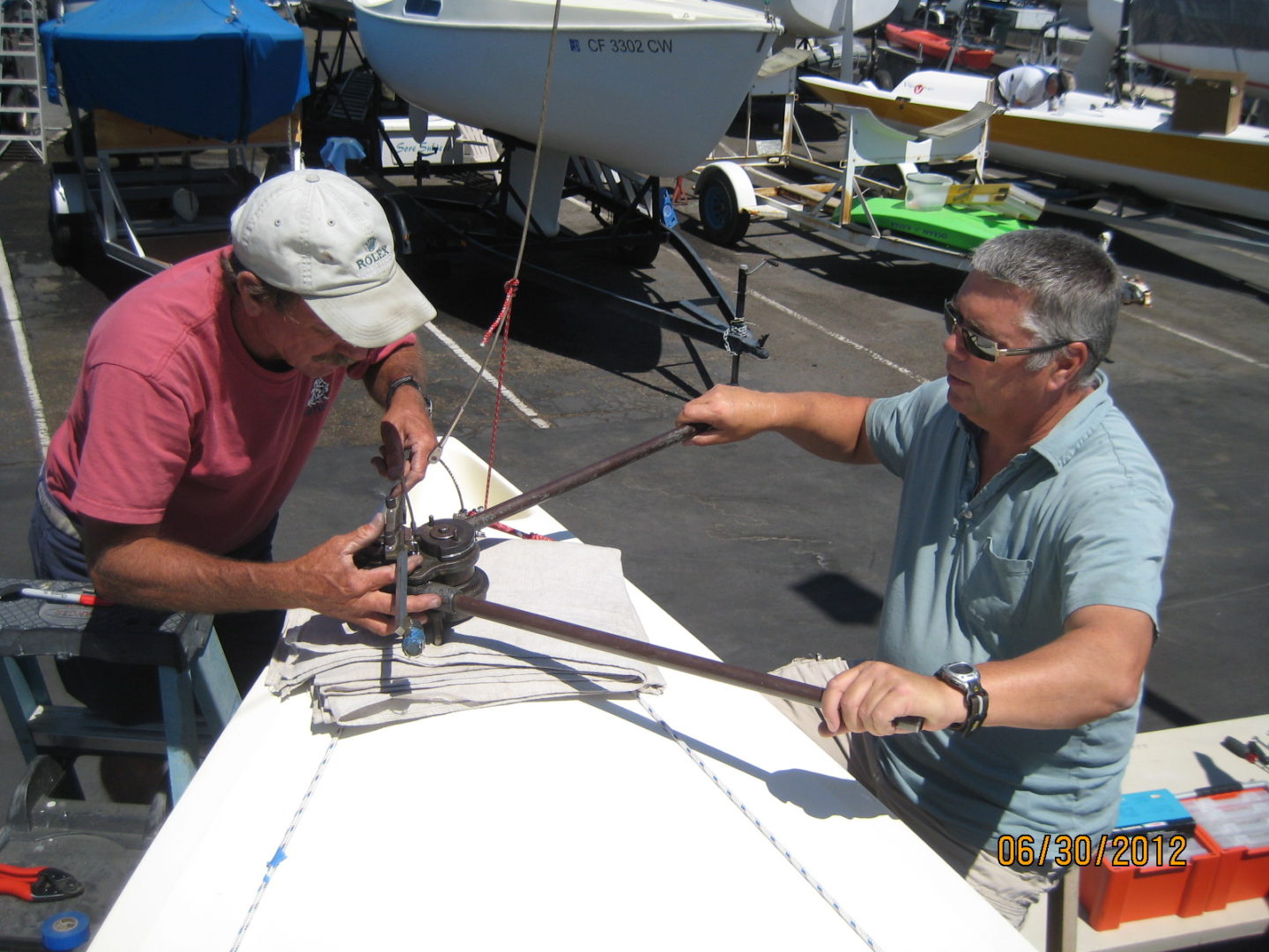 Two men working on a boat in the water.