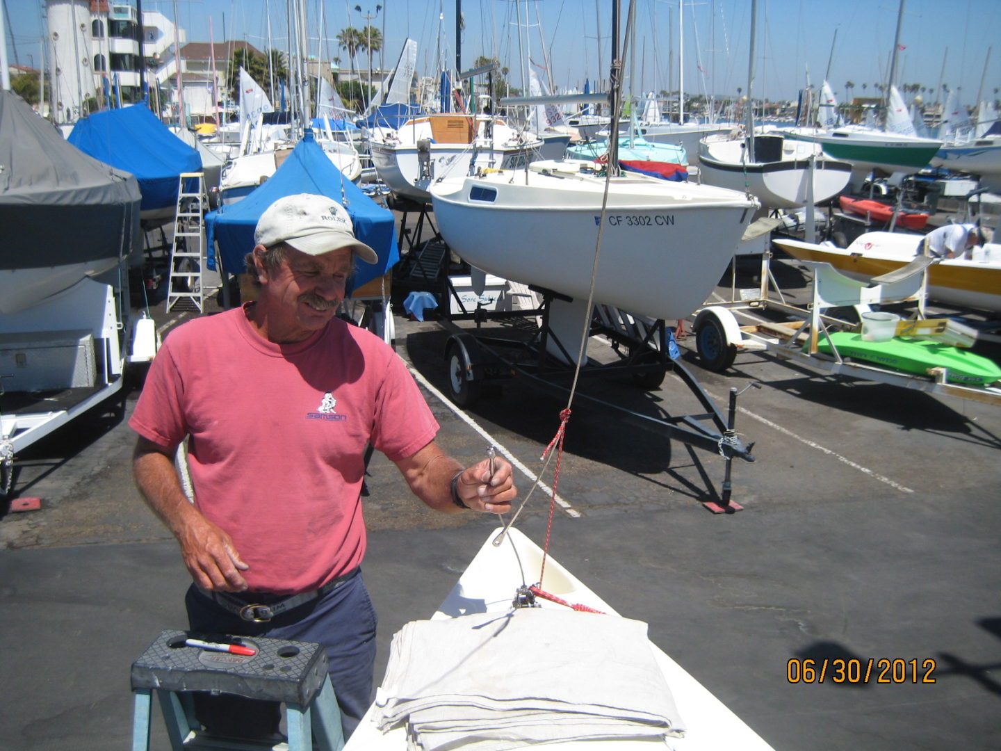 A man standing in front of boats on the water.