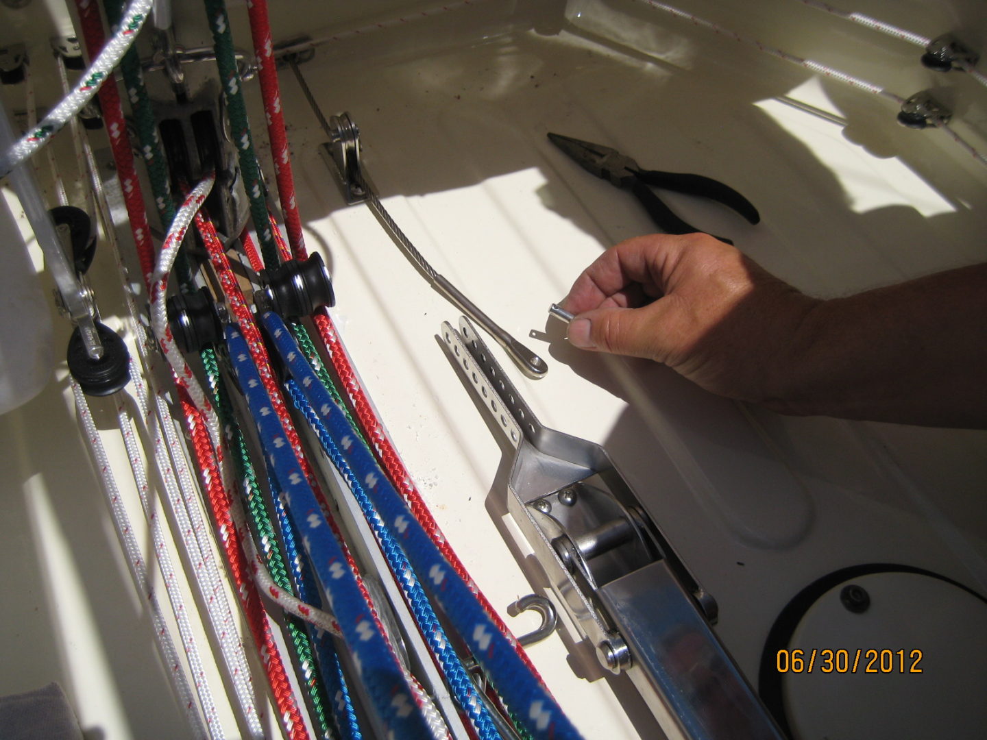 A person working on some skis in the sun.