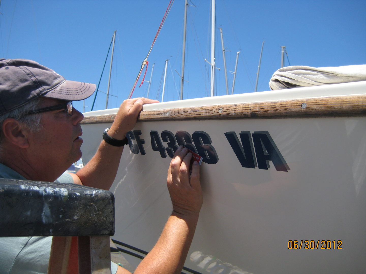 A man is writing on the side of a boat.