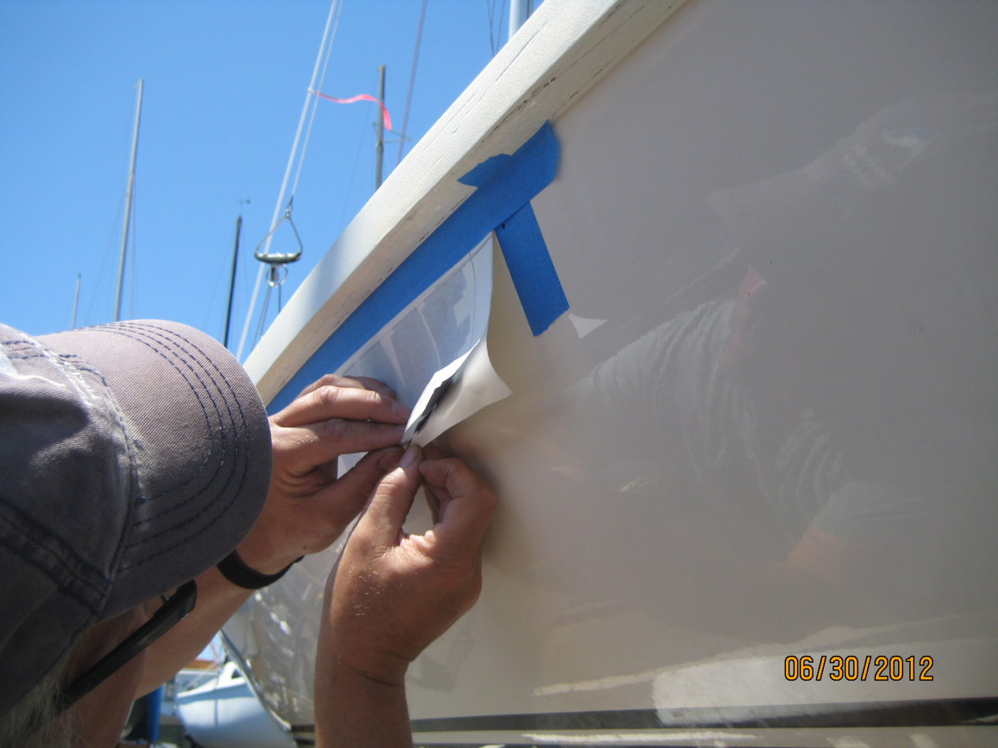 A man is painting the side of a boat.