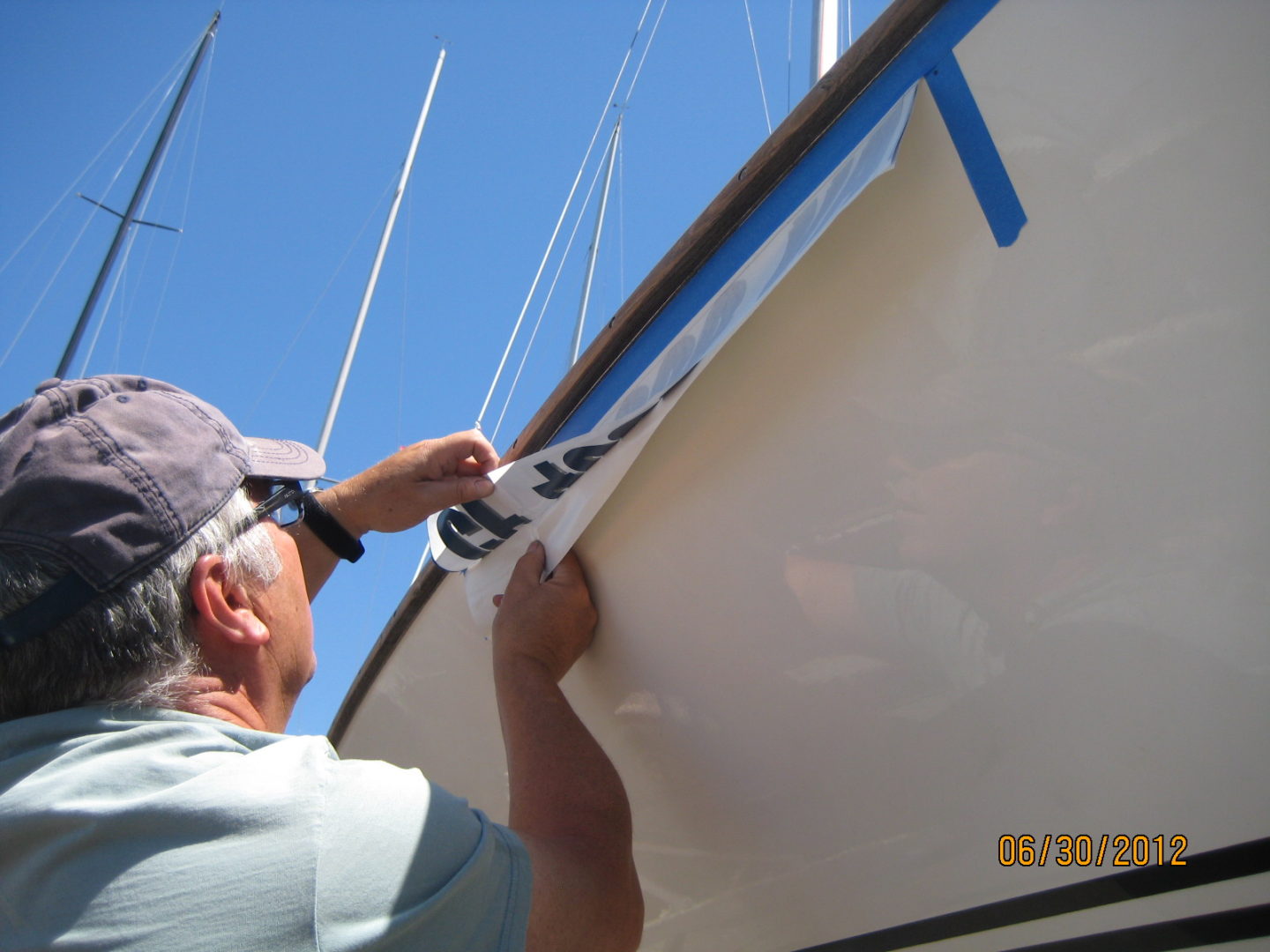 A man is painting the side of a boat.