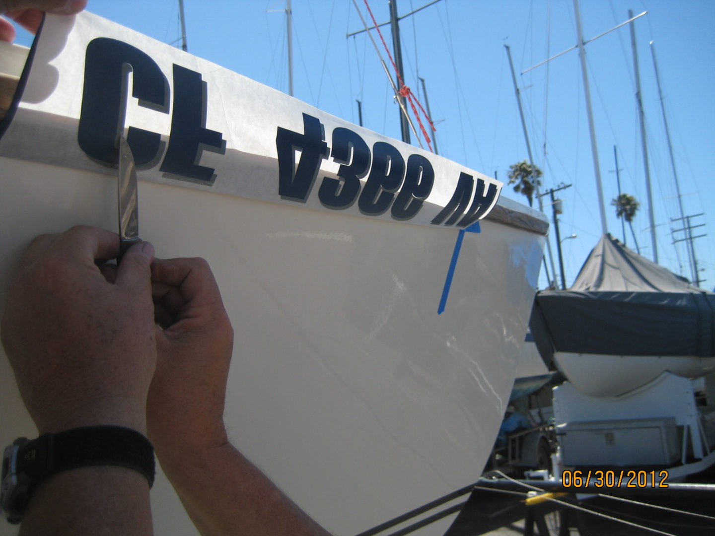 A person writing on the side of a boat.